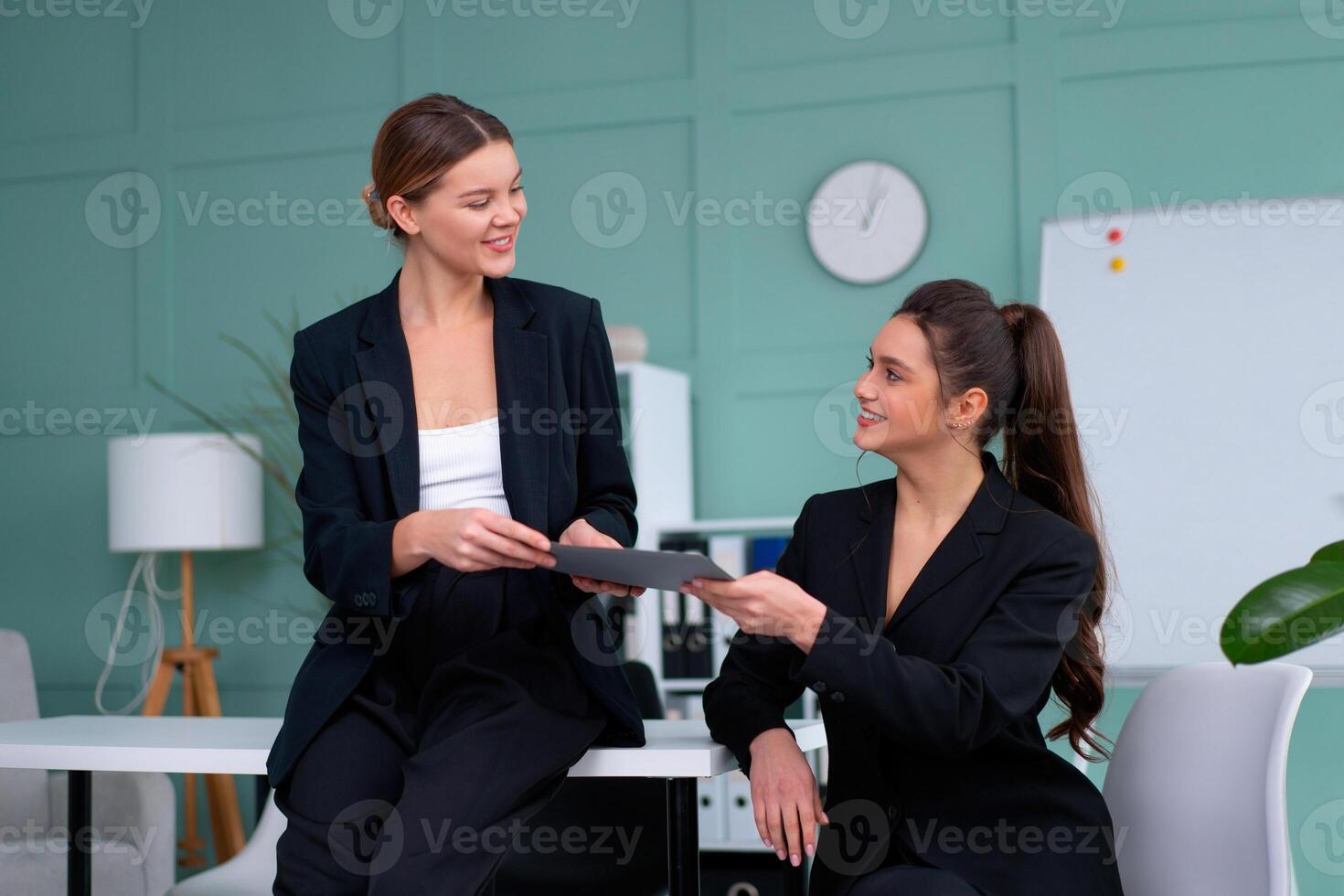 ung kvinnor ledare är kontroll finansiell uttalanden från papper dokument. två kvinna självsäker företag arbetstagare klädd svart kostym i kontor kontroll finansiell dokumentera foto