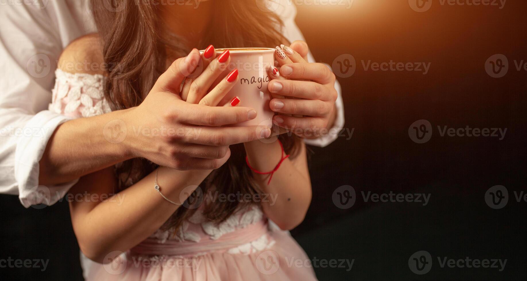 oigenkännlig man och kvinna håll med två händer en råna av varm kaffe. par i kärlek. kärlek vård begrepp. foto