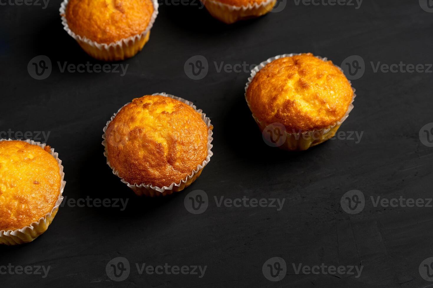 aptitlig muffins stå på en tabell topp se. traditionell bakverk på en mörk bakgrund minimalism. foto