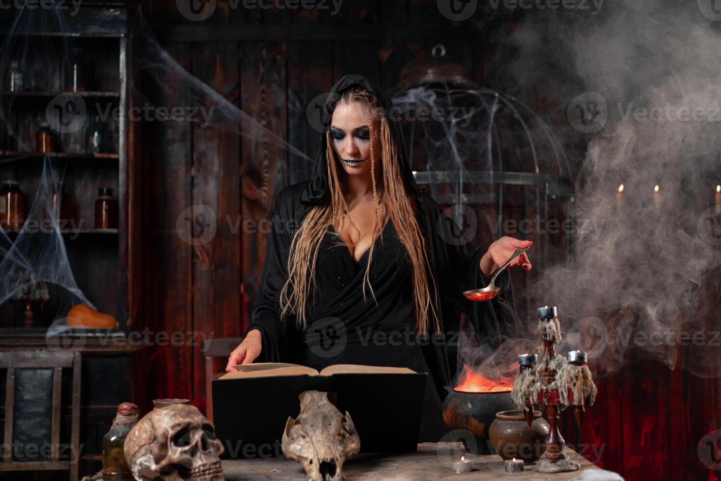 halloween, häxa använda sig av magi bok och kittel förbereda förgifta eller kärlek trolldryck foto