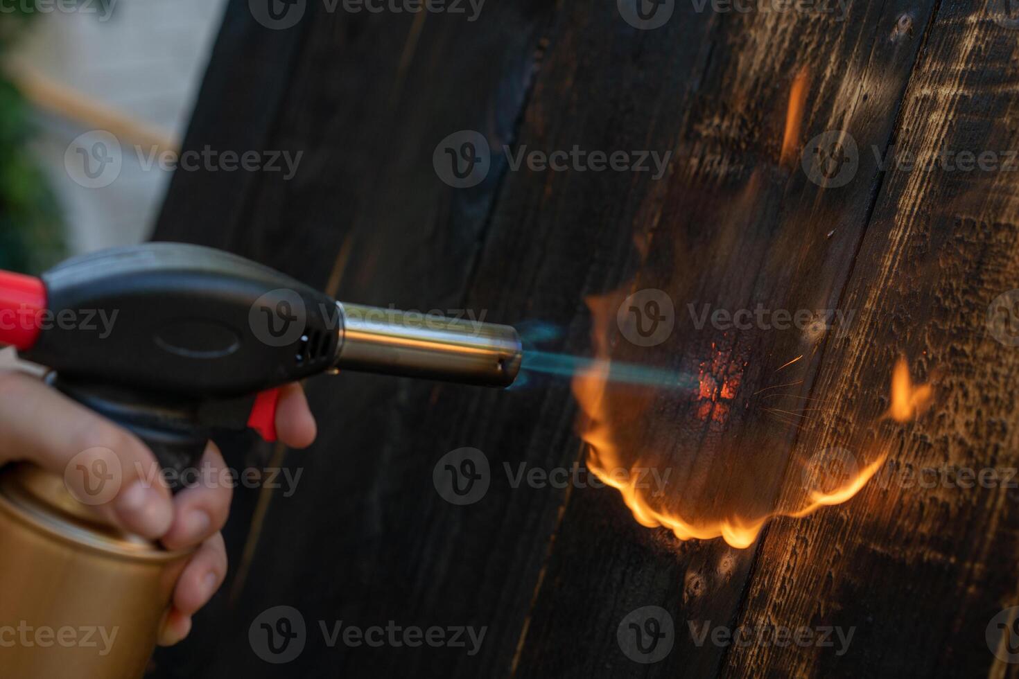 professionell snickare använder sig av gammal traditionell japansk Metod. brinnande trä plankor med gas brännare foto