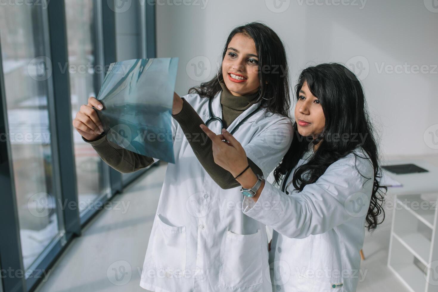indisk läkare analysera de röntgen i en modern klinik. indisk medicinsk studenter praktikanter. högre utbildning för kvinna foto