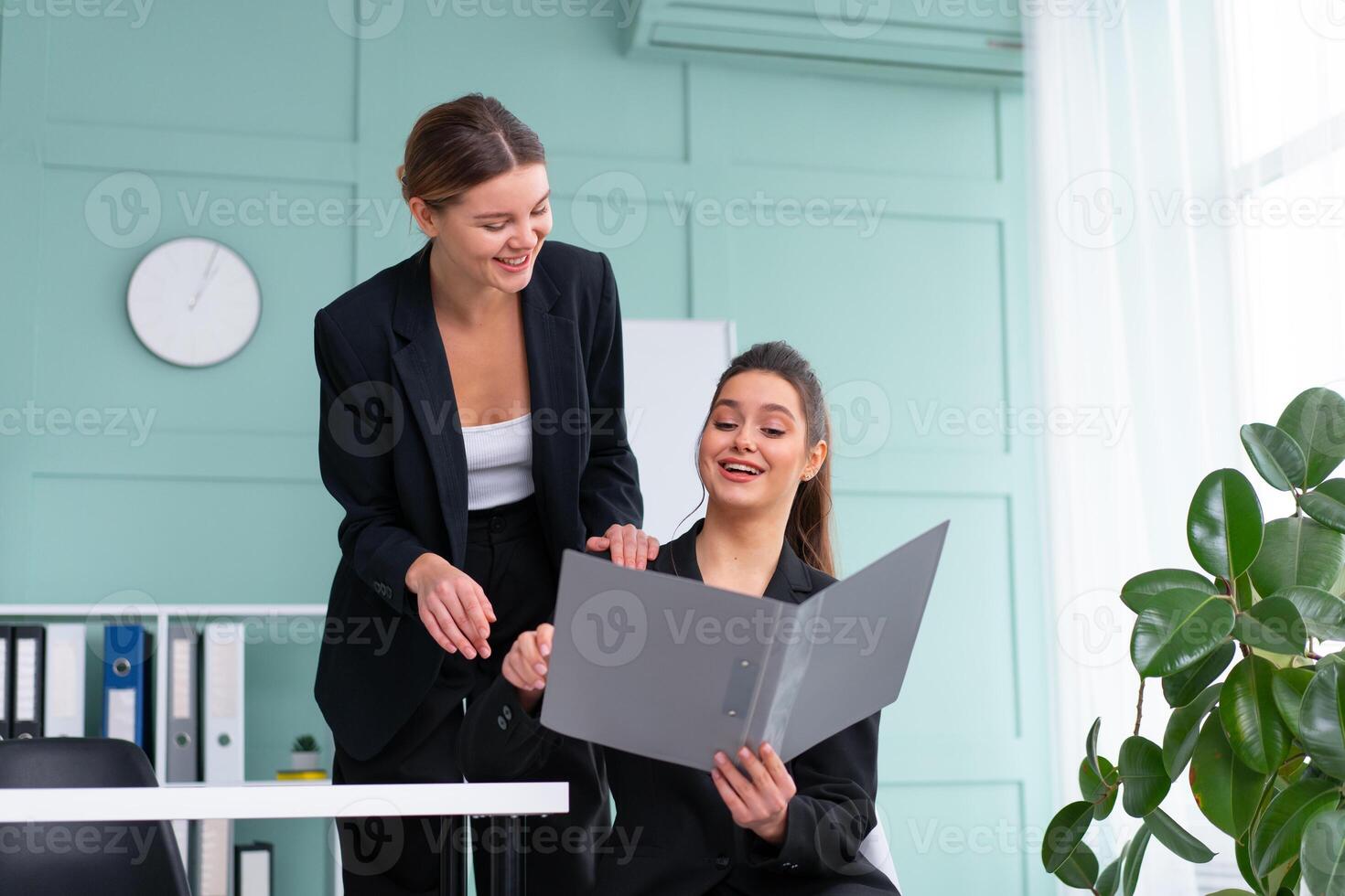 ung kvinnor ledare är kontroll finansiell uttalanden från papper dokument. två kvinna självsäker företag arbetstagare klädd svart kostym i kontor kontroll finansiell dokumentera foto