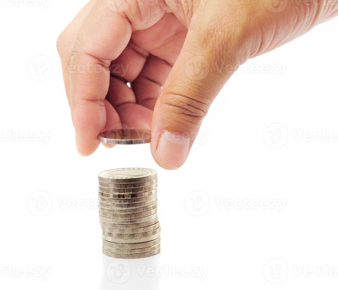 finger sätt mynt på mynt-stack foto