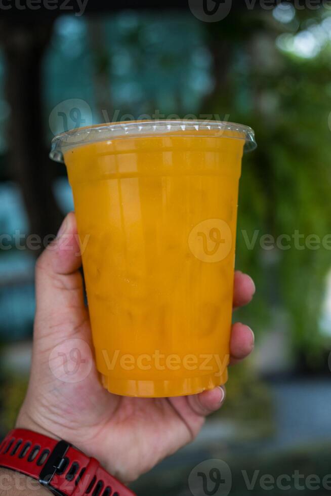 orange kall nedtryckt juice i plast kopp. foto