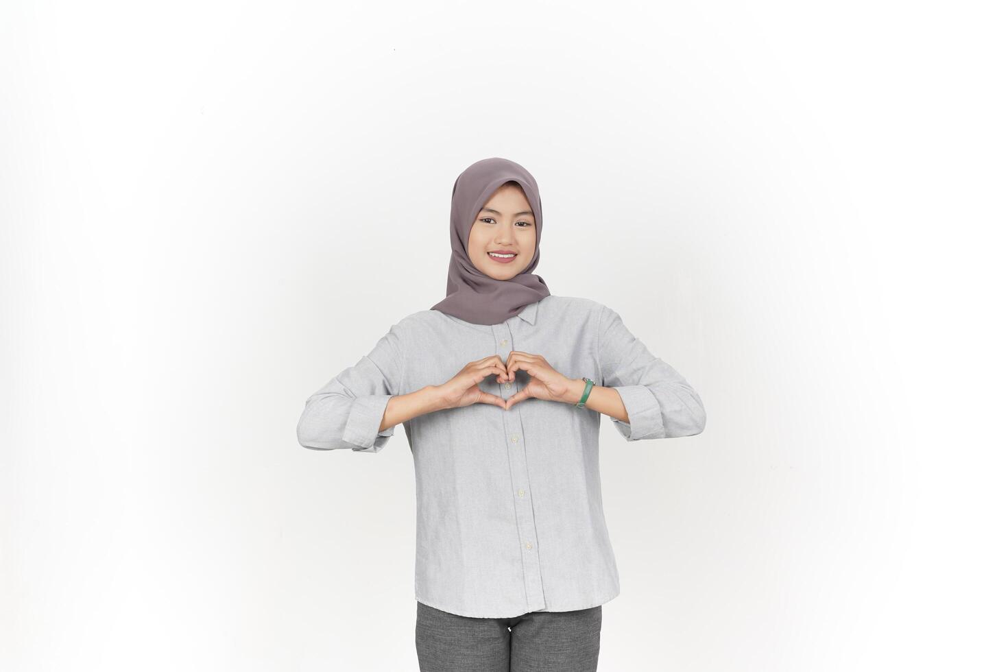 ung asiatisk kvinna bär hijab som visar kärlek hjärta tecken isolerat på vit bakgrund foto