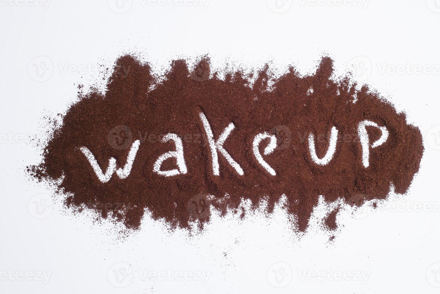 vakna upp ord skriven på jord kaffe lager, vit bakgrund foto