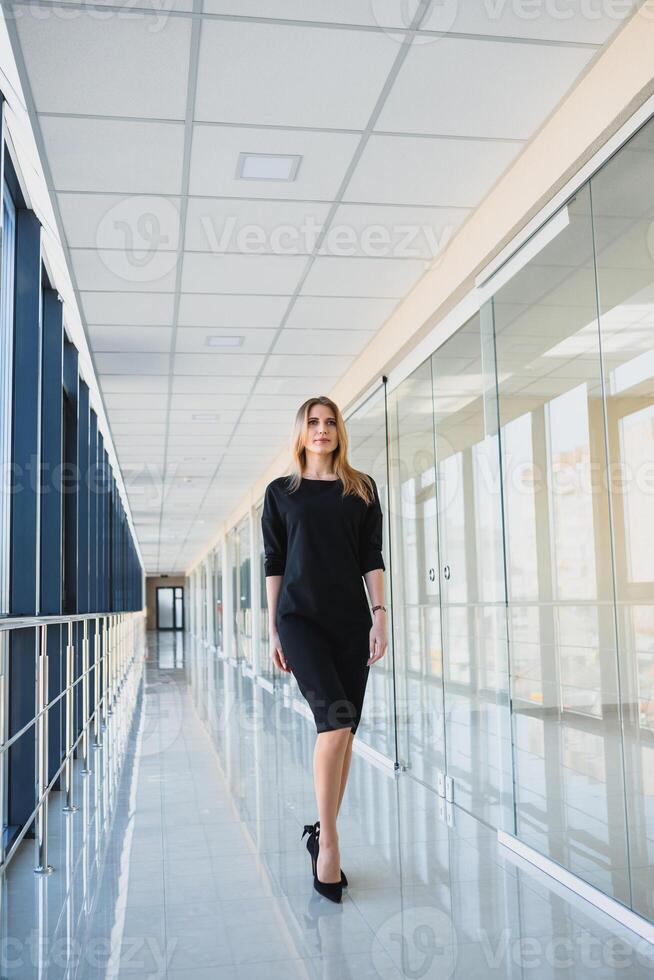 attraktiv företag kvinna med en svart klänning i de kontor foto