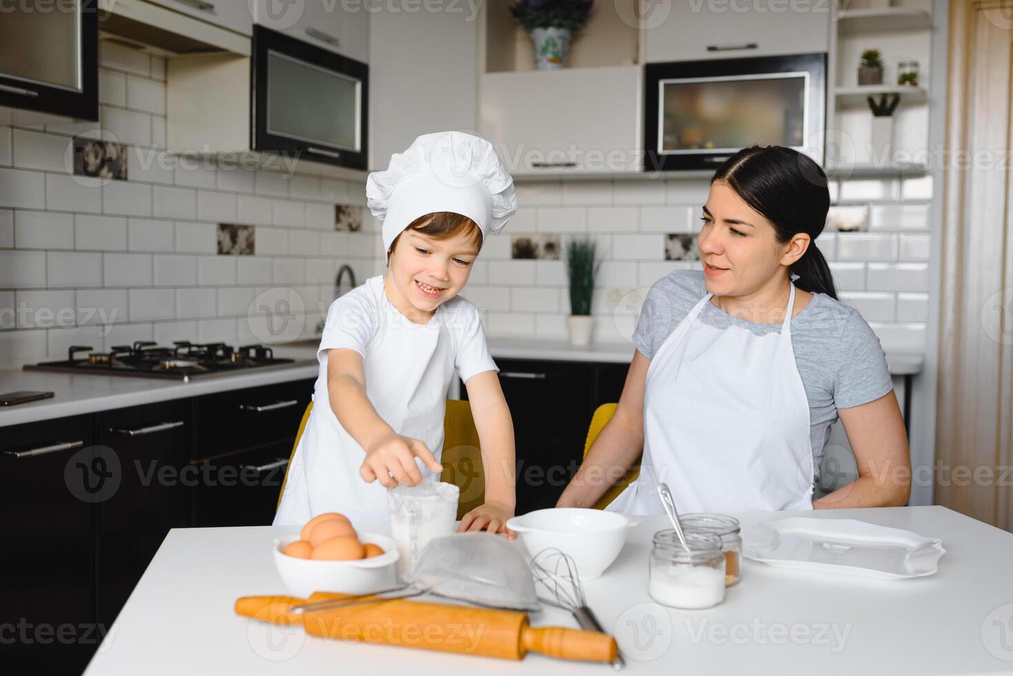 Lycklig familj. mor undervisning henne son på vilket sätt till matlagning kaka meny i morgon. friska livsstil begrepp.. bakning jul kaka och laga mat begrepp foto