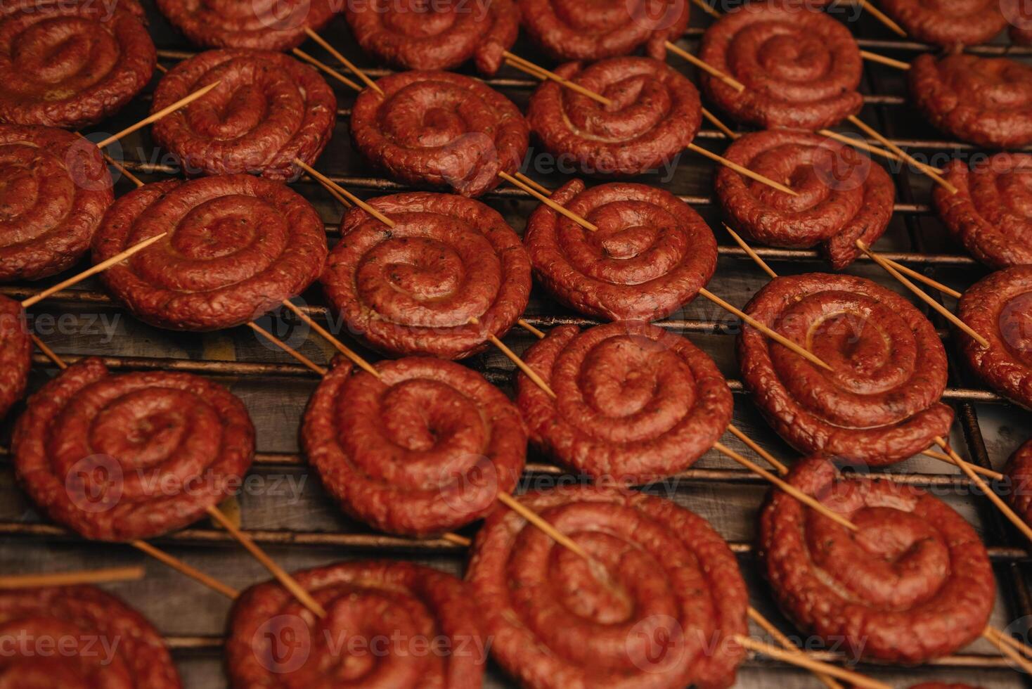 friterad spiral korvar på ett elektrisk utegrill bbq grill. elektrisk griddle till laga mat mat. tysk bratwurst fläsk korv. foto