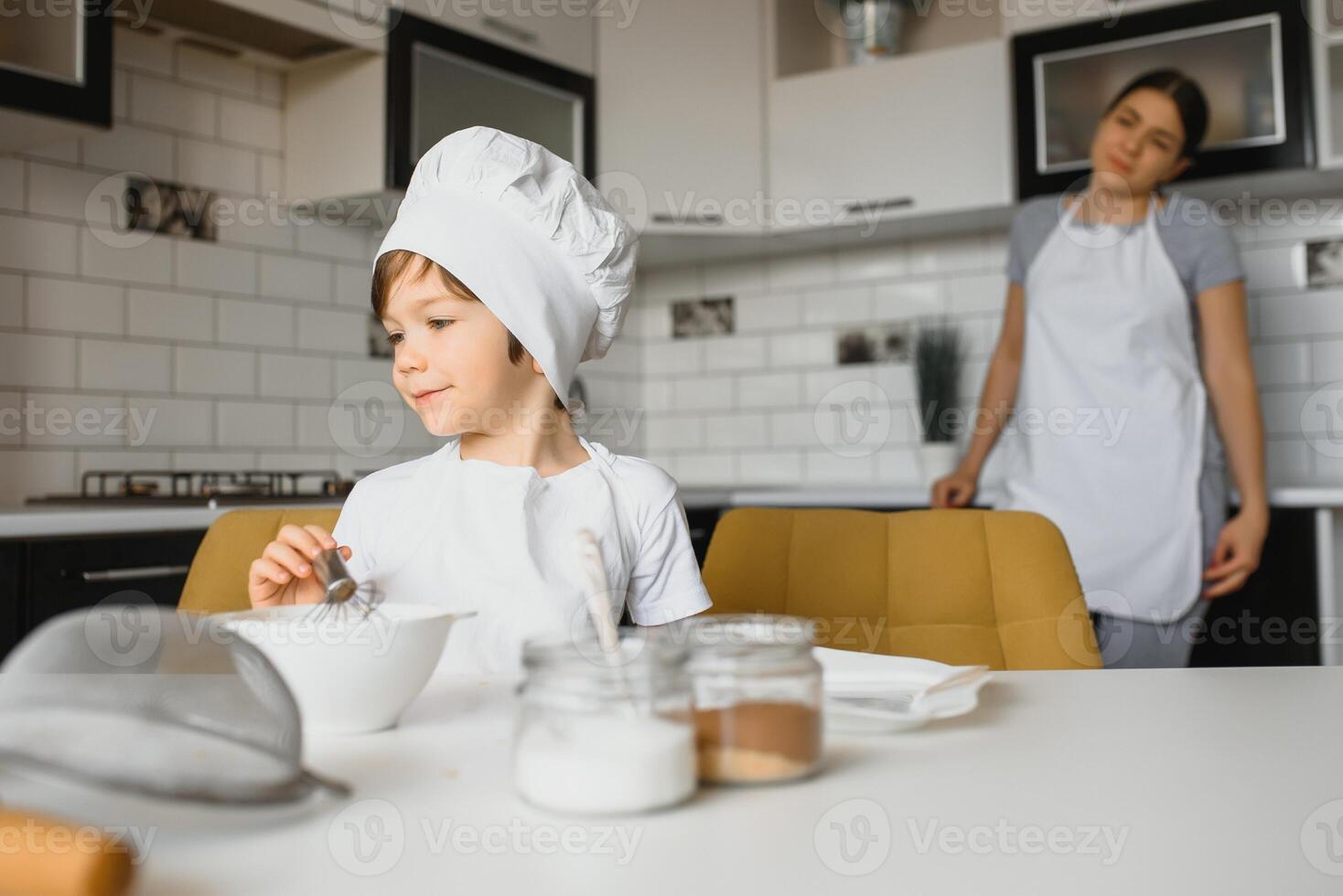 Lycklig familj. mor undervisning henne son på vilket sätt till matlagning kaka meny i morgon. friska livsstil begrepp.. bakning jul kaka och laga mat begrepp foto