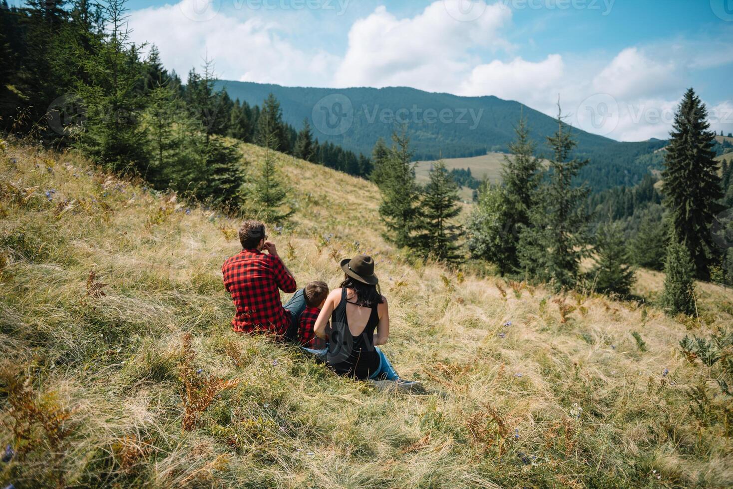 ung familj med barn vilar på en berg. semester i de nationell parkera foto