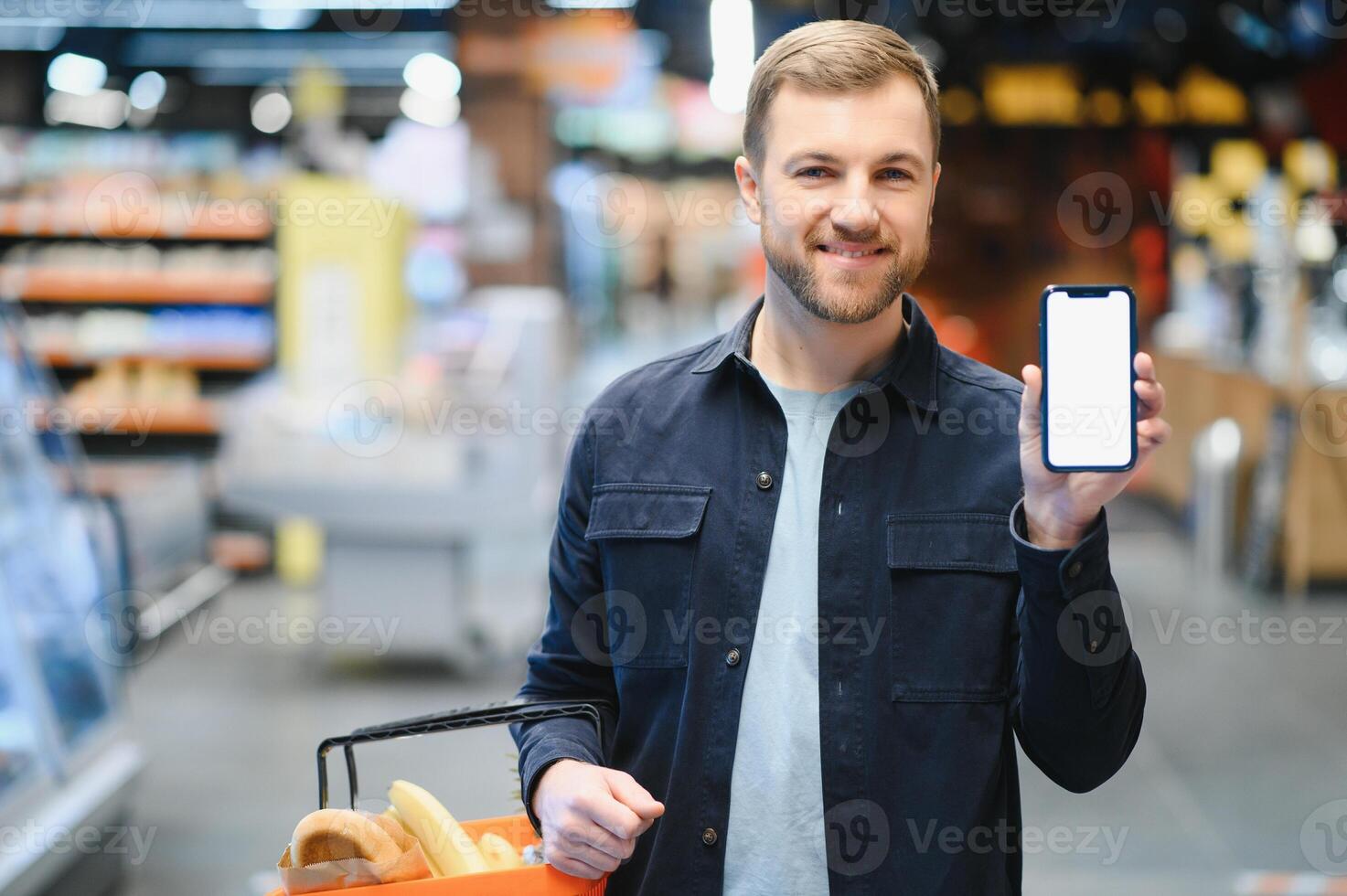 man använder sig av smartphone i mataffär. foto