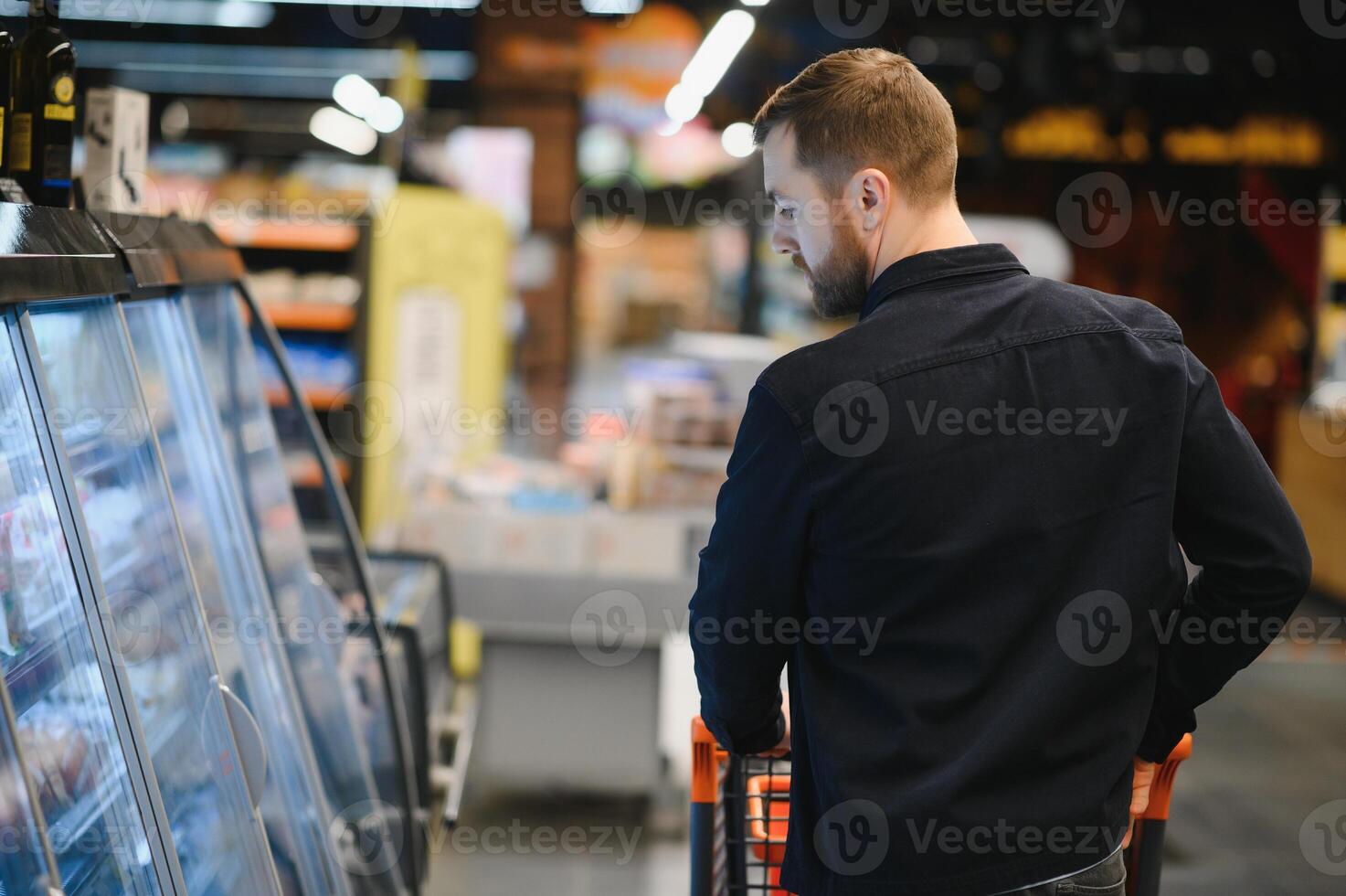 ung man uppköp specerier på de mataffär. Övrig kunder i bakgrund. konsumentupplysning begrepp. foto