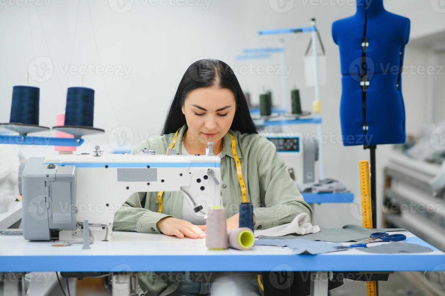 ung kvinna arbetssätt som sömmerska i Kläder fabrik. foto