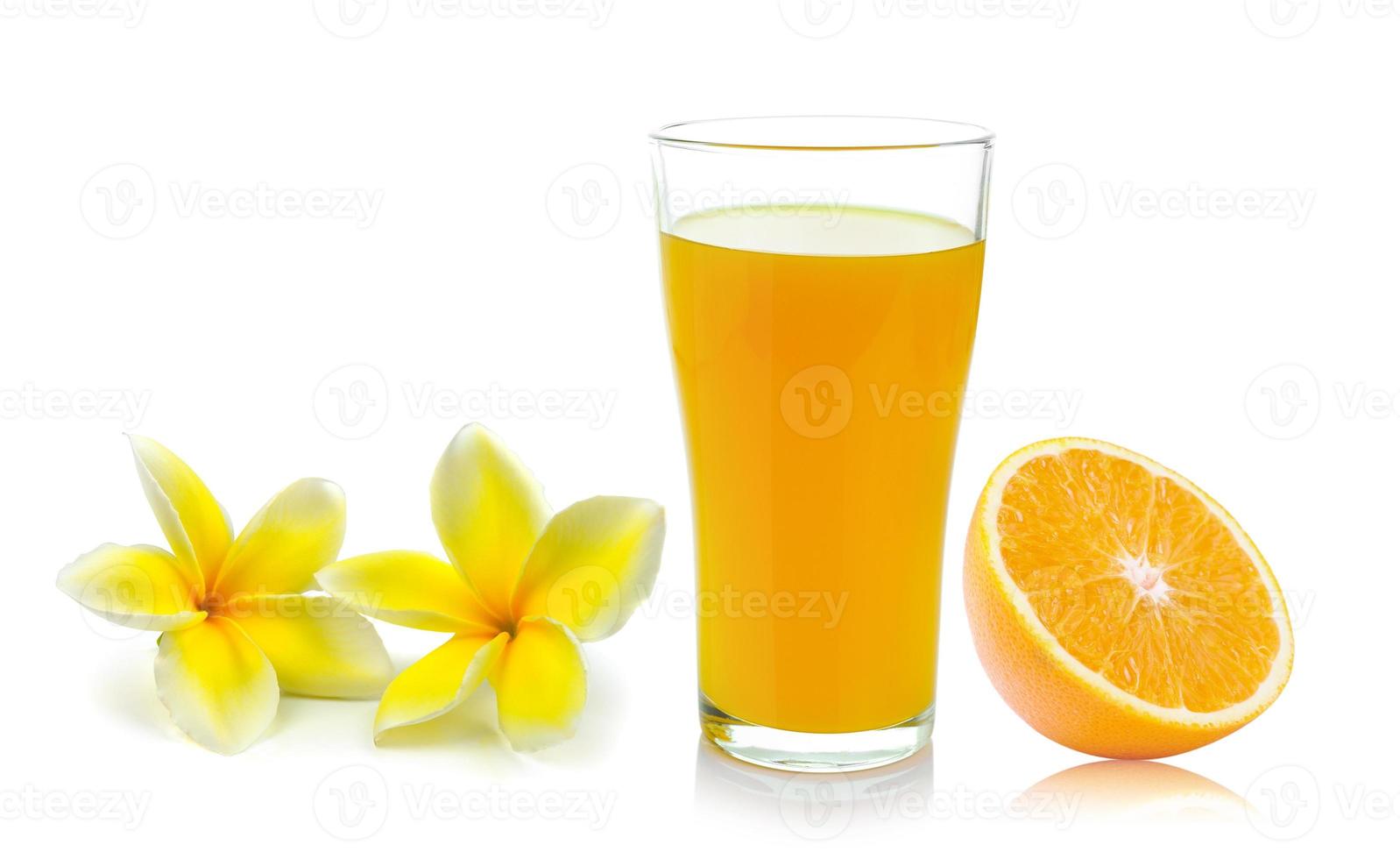 färskt apelsinglas med juice och frangipani blomma foto