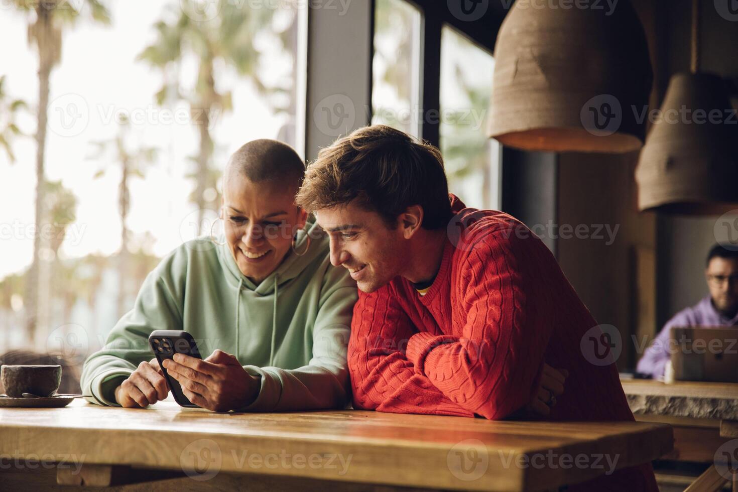 vänner tittar på på de cell telefon i en kaffe bar foto