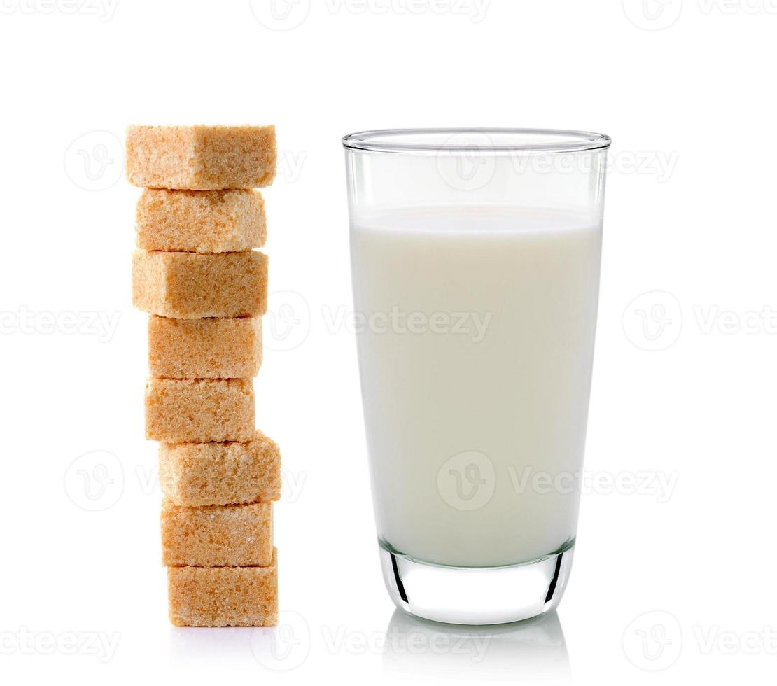glas mjölk och kuber av rörsocker isolerad på vit bakgrund foto
