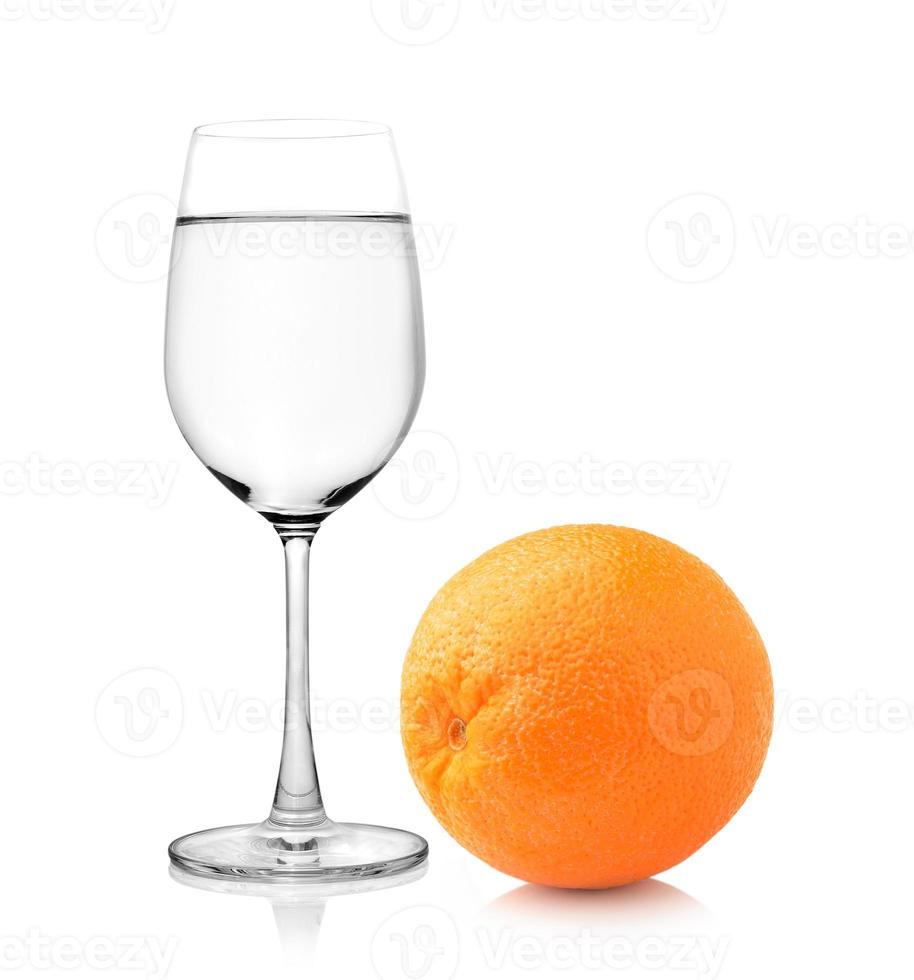 glas vatten och orange frukt på vit bakgrund foto