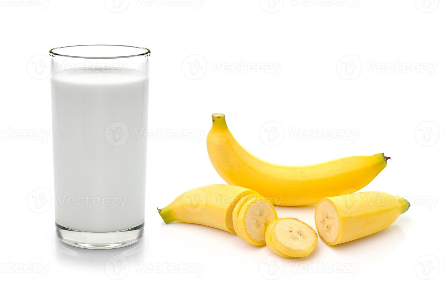 glas mjölk med banan över vit bakgrund foto