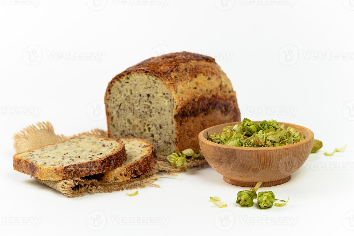 organisk bröd av hela spannmål mjöl och hopp surdeg. torr hopp blommor i trä- skål och hemlagad bröd. hantverk bageri begrepp foto