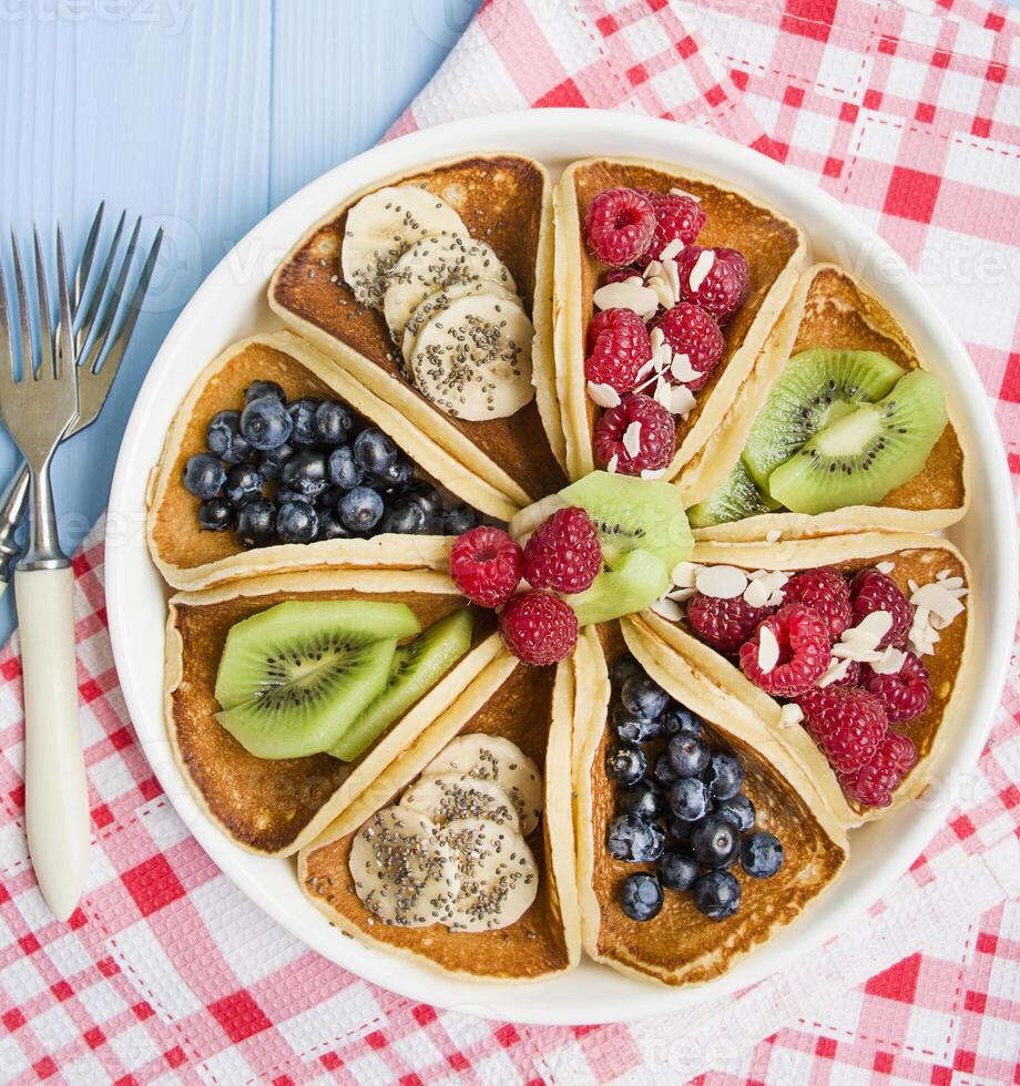 klassisk amerikan pannkakor med frukt på en ljus bakgrund. topp se, närbild. foto