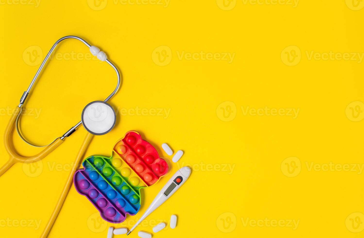 pediatrik begrepp. stetoskop och leksak på gul bakgrund. kopia Plats. foto