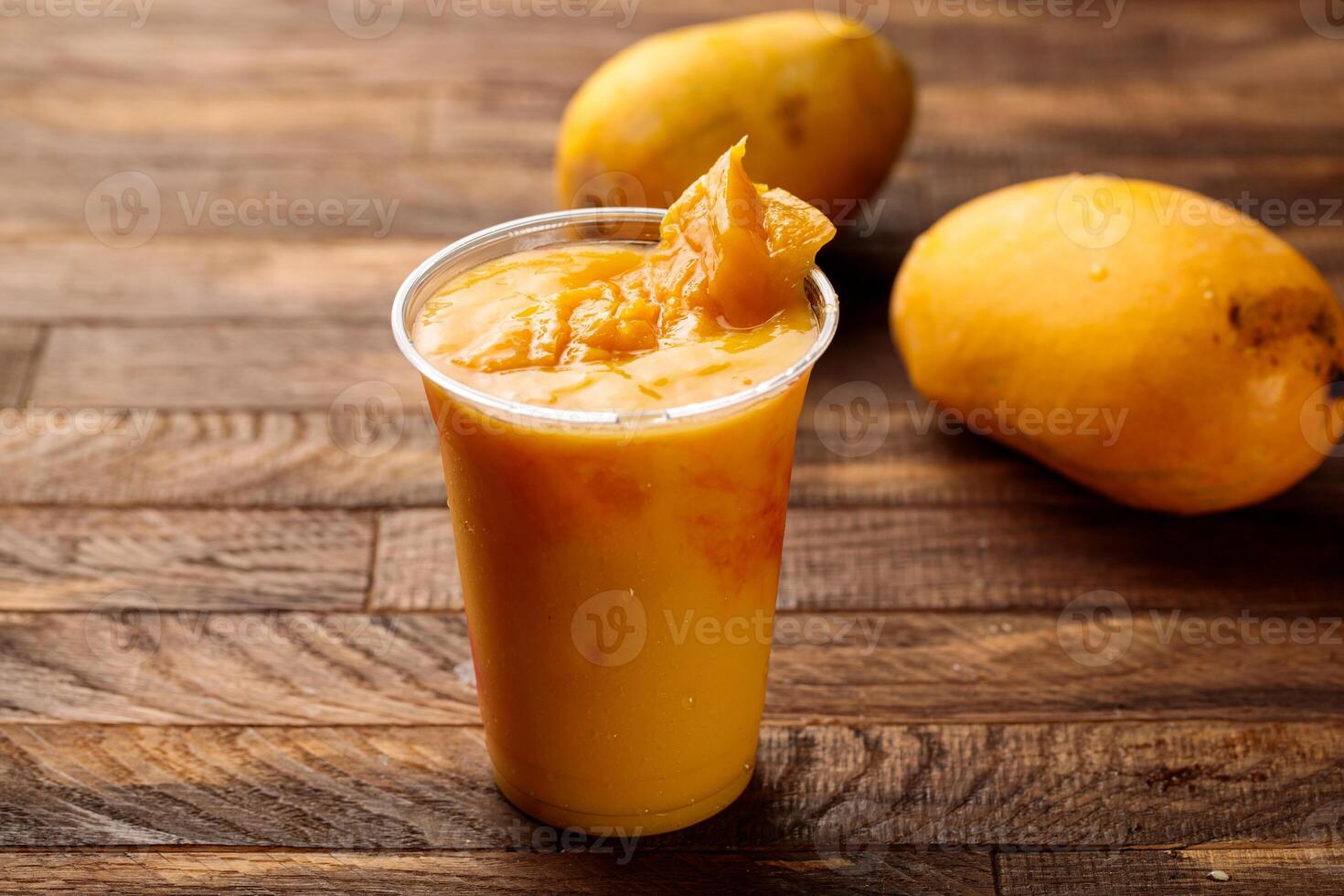 färsk mango juice med mango skiva eras i glas sida se på trä- tabell morgon- måltid foto