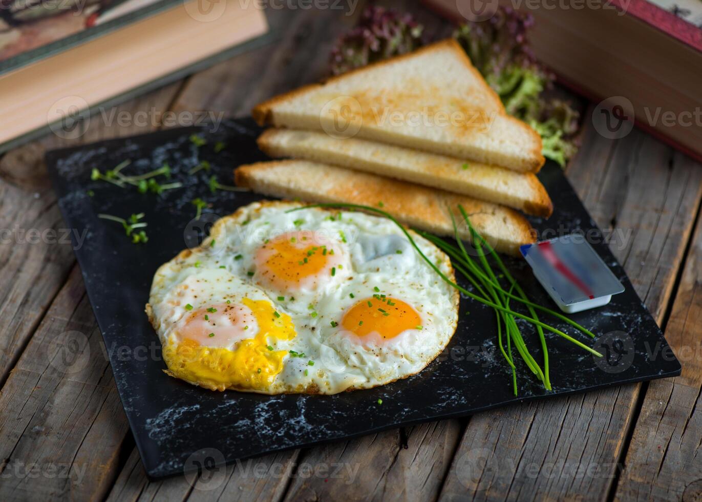 solig sida upp ägg med skivad bröd eras i en maträtt isolerat på skärande styrelse sida se av frukost på trä- bakgrund foto