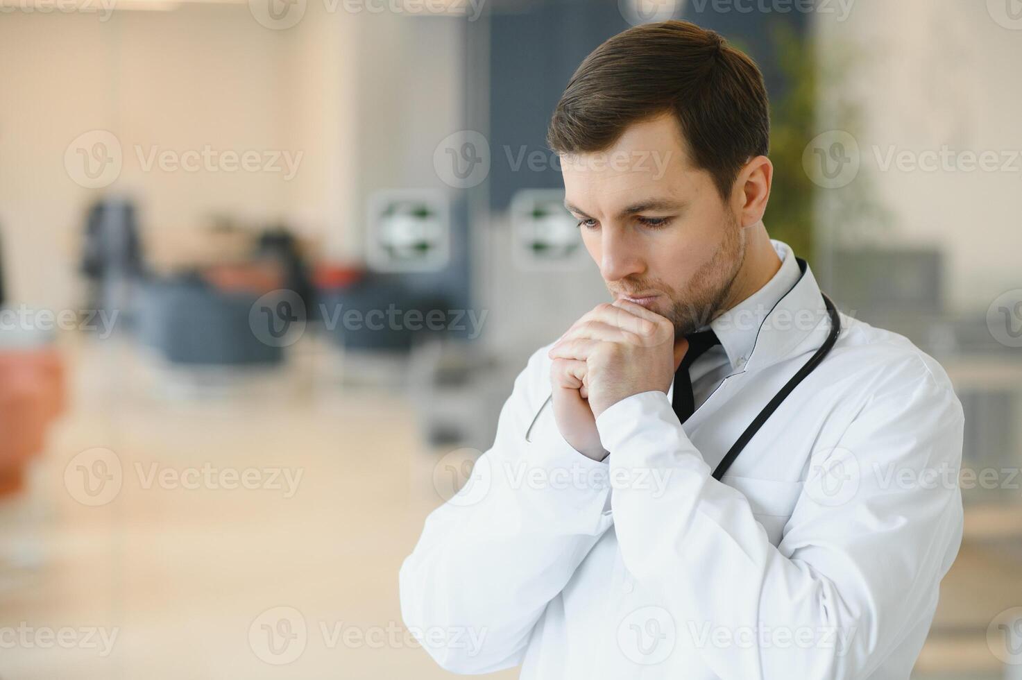bön- för en framgångsrik drift. beskurna skott av en stilig manlig läkare bön. foto