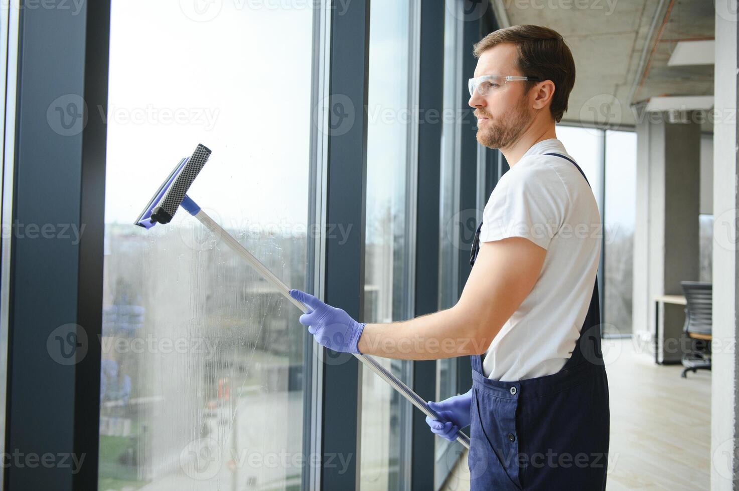 ett anställd av en professionell rengöring service tvättar de glas av de fönster av de byggnad. monter rengöring för butiker och företag. foto