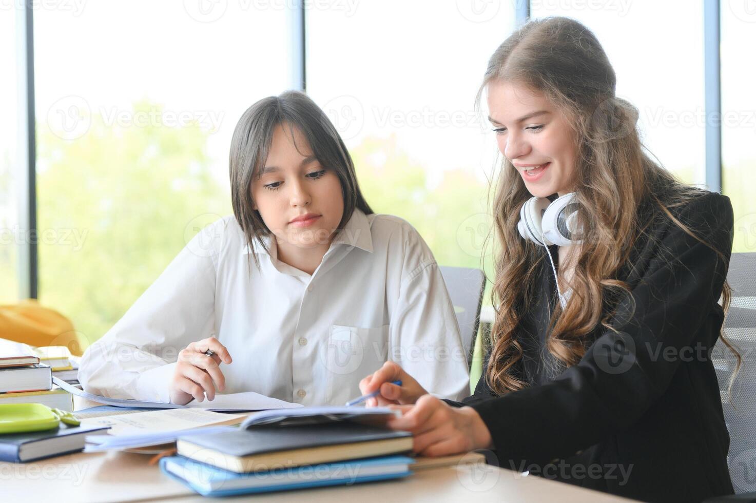 porträtt av två flickor på arbetsplats med böcker. skola utbildning foto