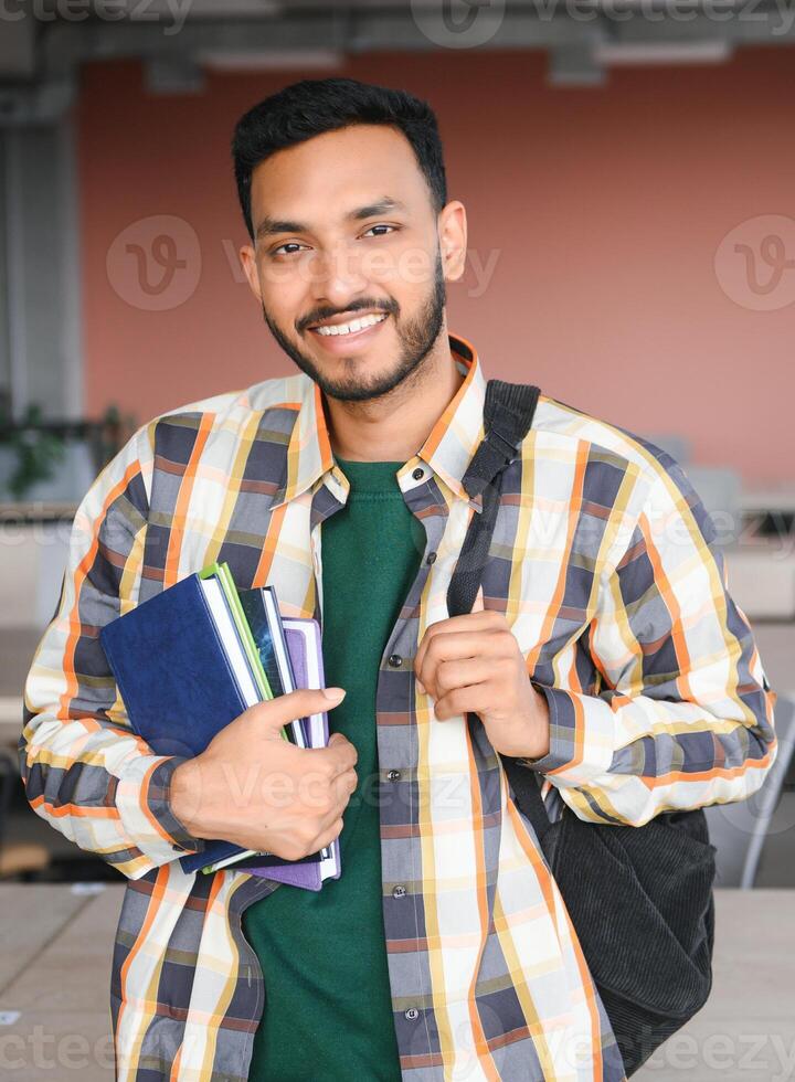 Lycklig indisk manlig studerande på de universitet foto
