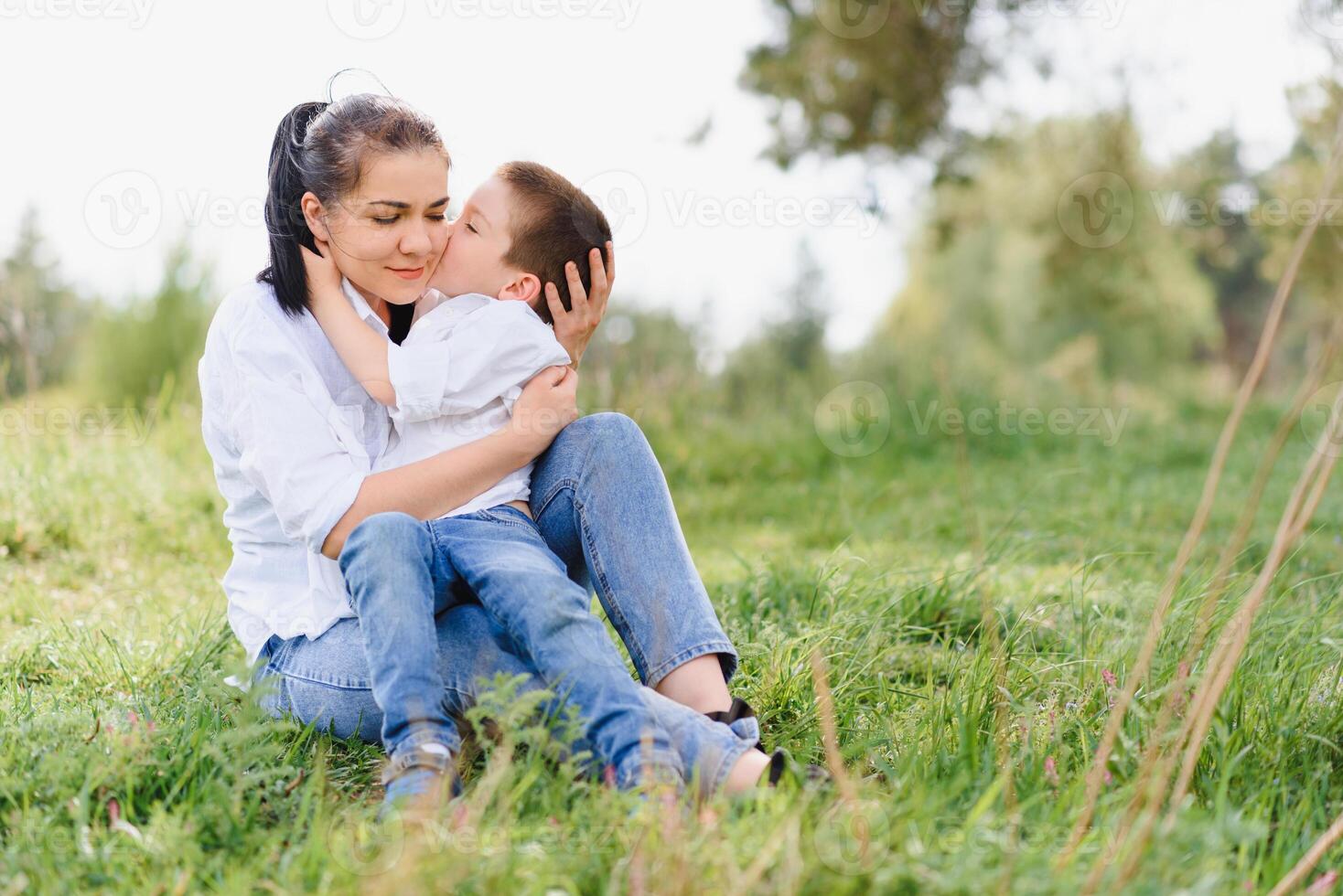 Lycklig ung mor är spelar med henne bebis i en parkera på en grön gräsmatta. lycka och harmoni av familj liv. bra familj semester. Bra helgen. mödrar dag. Semester. de begrepp av en Lycklig familj foto