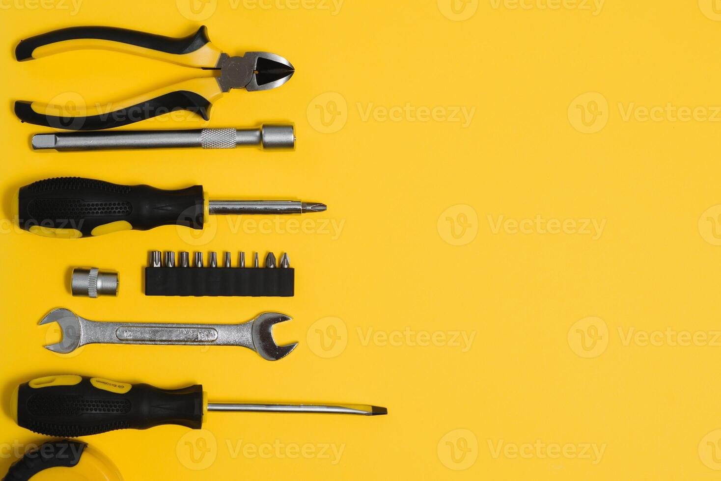 gul och svart praktisk verktyg pålar och skruvmejsel isolerat på gul bakgrund. foto