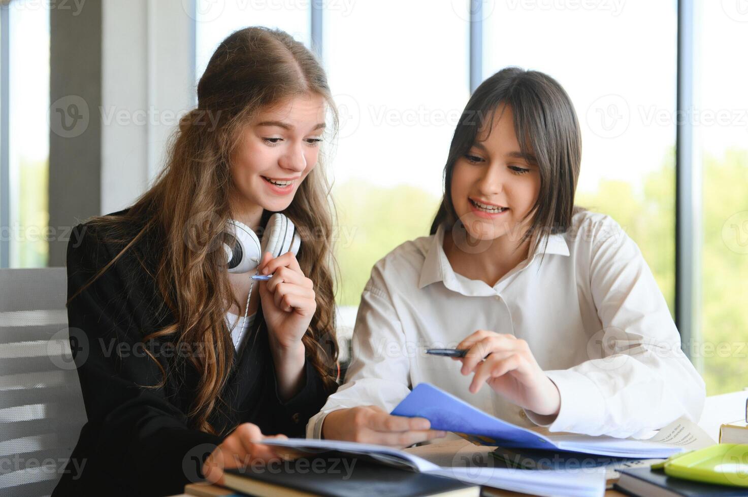 porträtt av två flickor på arbetsplats med böcker. skola utbildning foto