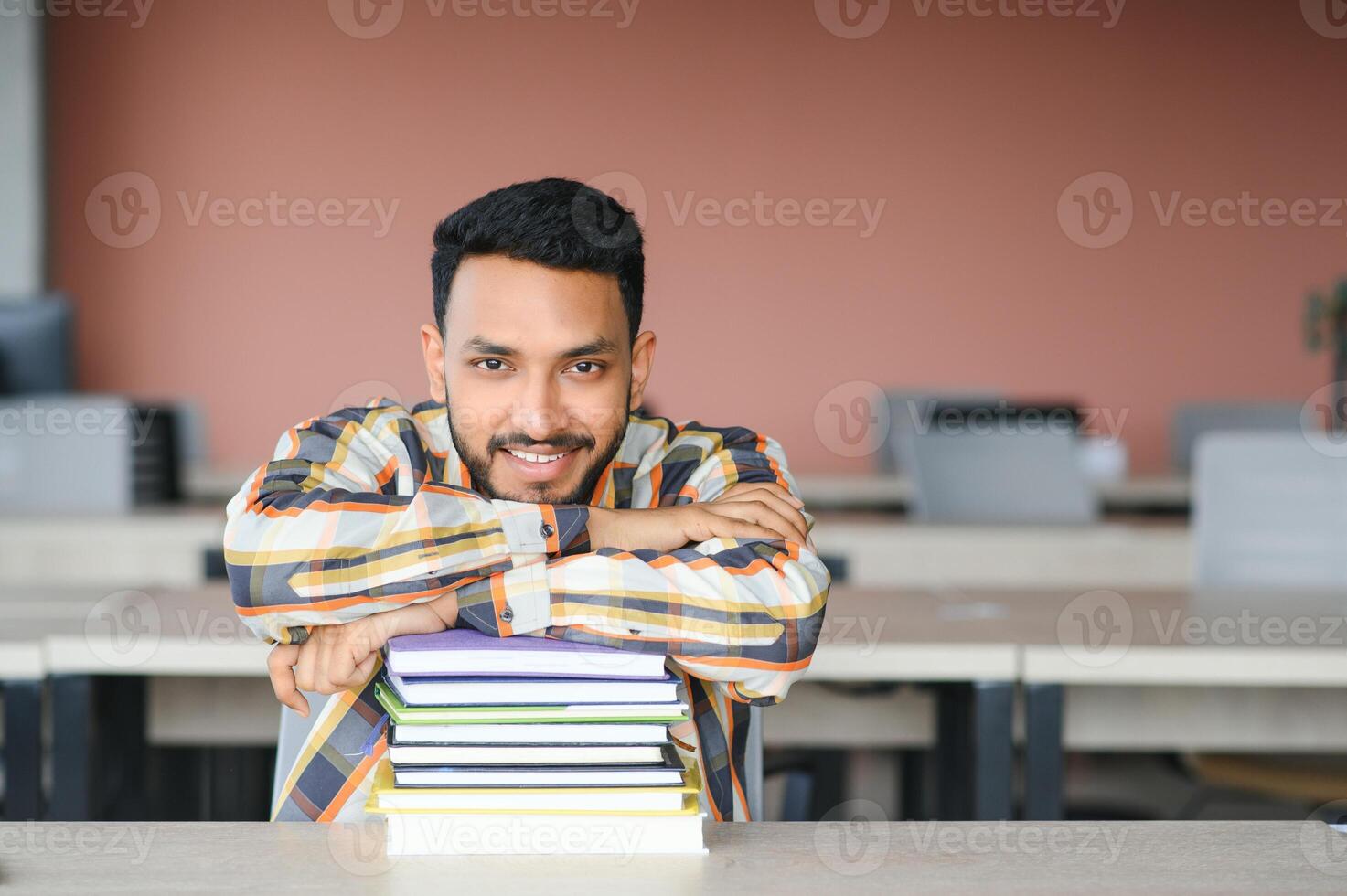 Lycklig indisk manlig studerande på de universitet foto