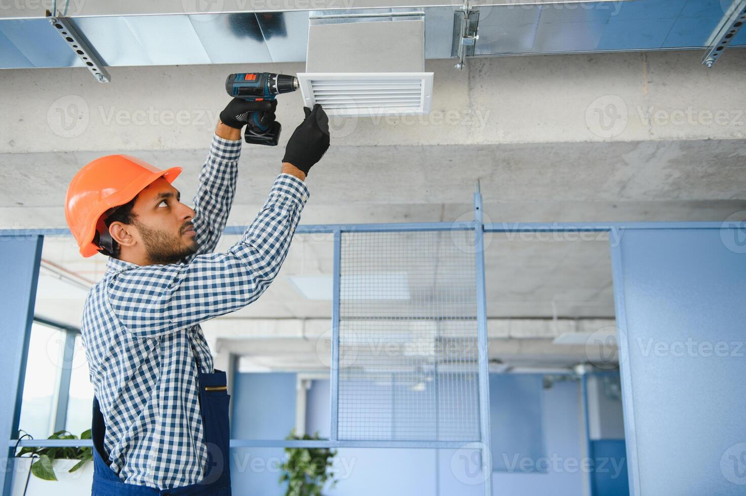 hvac tjänster - indisk arbetstagare Installera kanaliserad rör systemet för ventilation och luft konditionering i hus foto