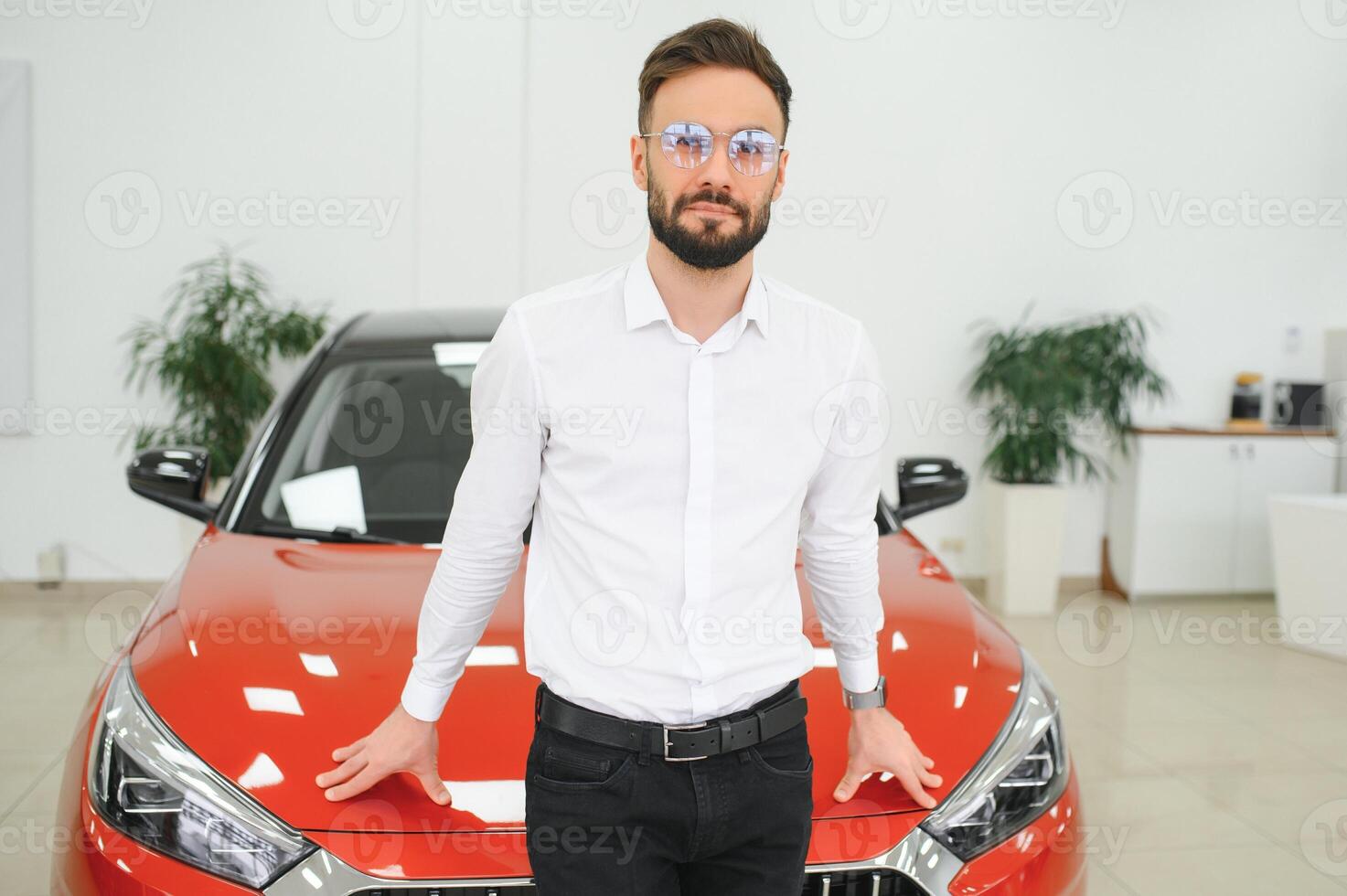 en man undersöker en bil i en bil återförsäljare foto