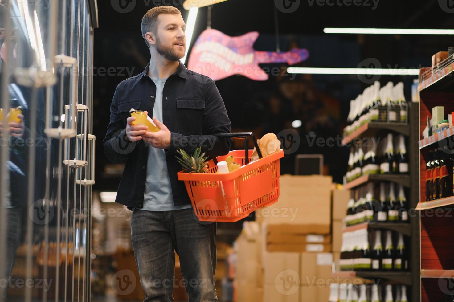 kund i mataffär. man håller på med matvaror handla stående med vagn välja mat produkt inomhus. kille uppköp specerier i mat Lagra. selektiv fokus, kopia Plats. foto