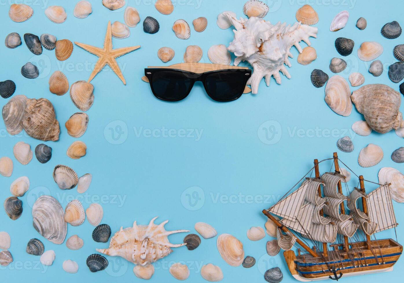 platt lägga. topp se. ram av skal av olika typer på en blå bakgrund. snäckskal och sjöstjärna och fartyg på en pastell bakgrund. semester begrepp. resa begrepp. med kopia Plats foto