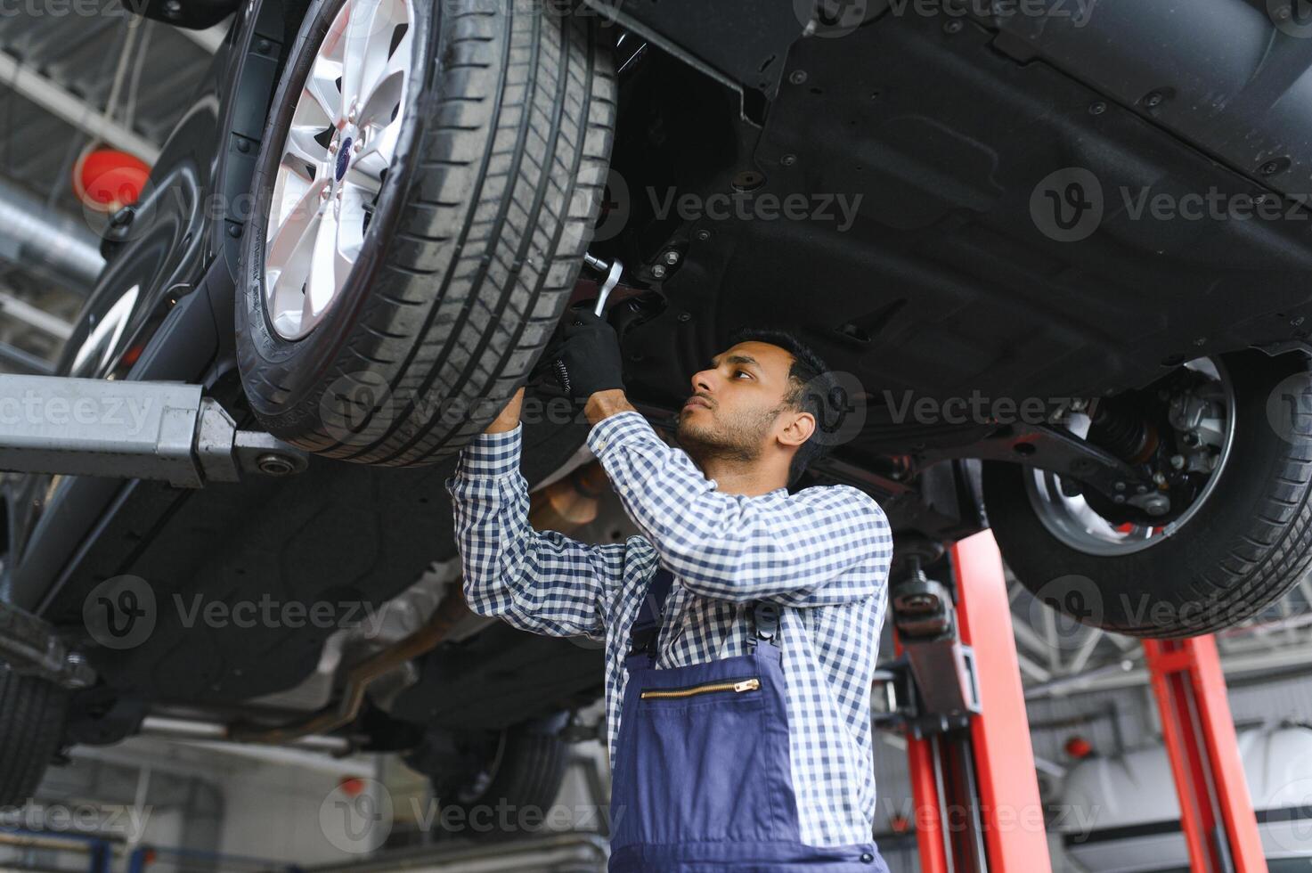 indisk Lycklig bil mekaniker i blå kostym. foto