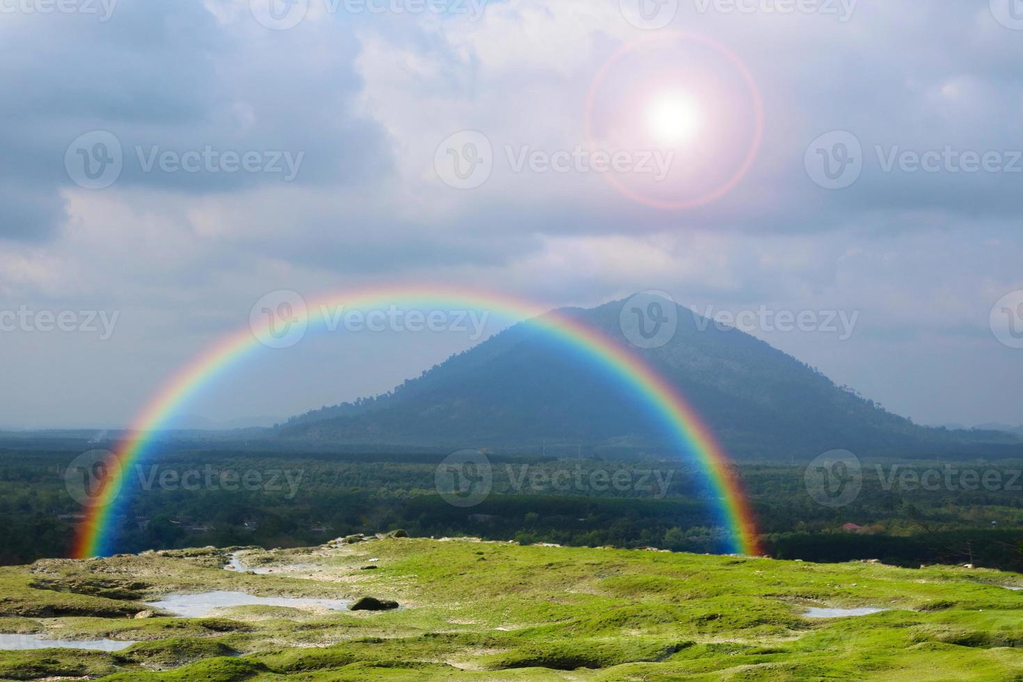 regnbåge på berget och sol på himlen tillbaka vitt moln foto