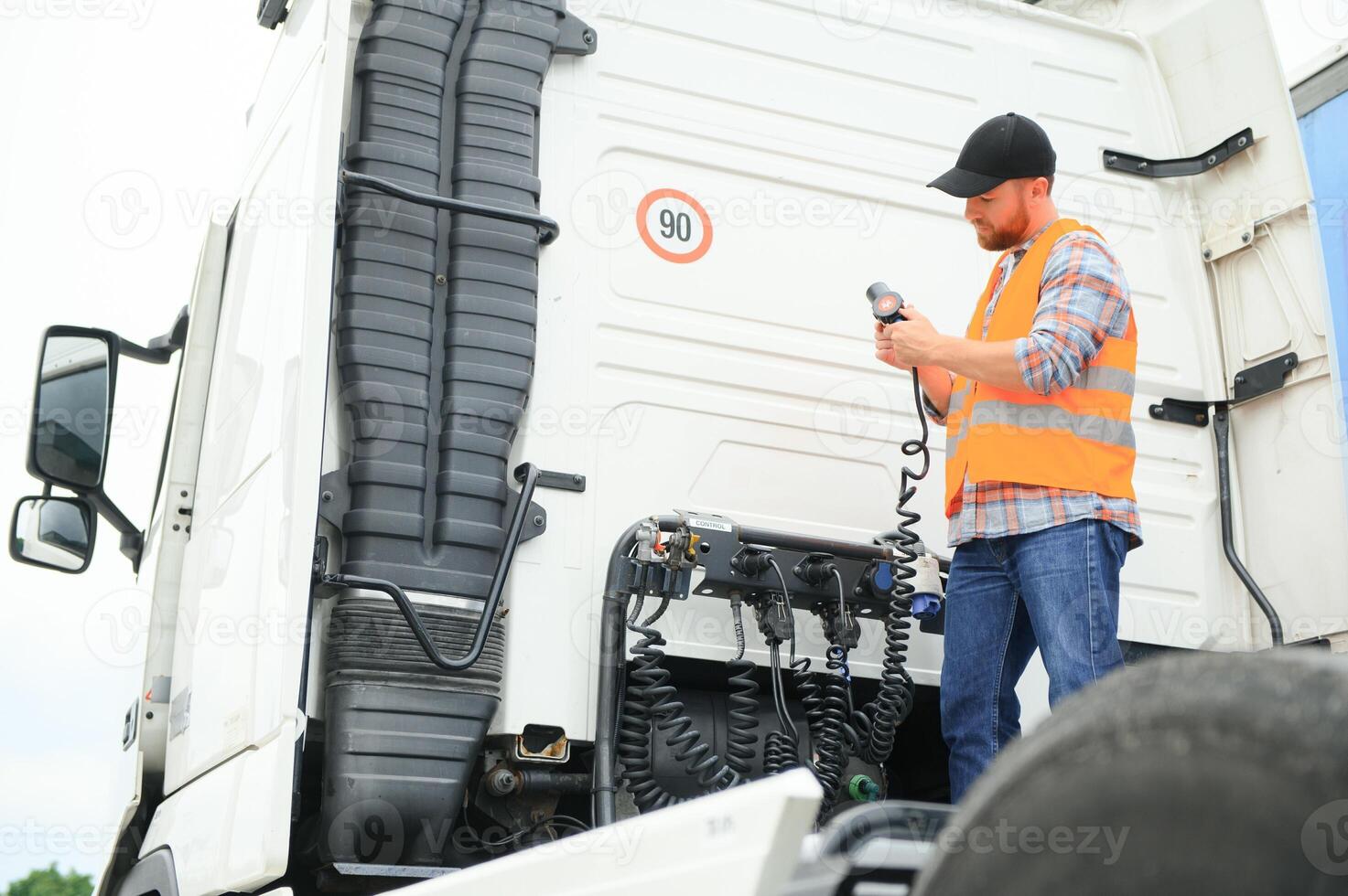se av en förare ansluter de kraft kablar till trailer av en kommersiell lastbil. foto