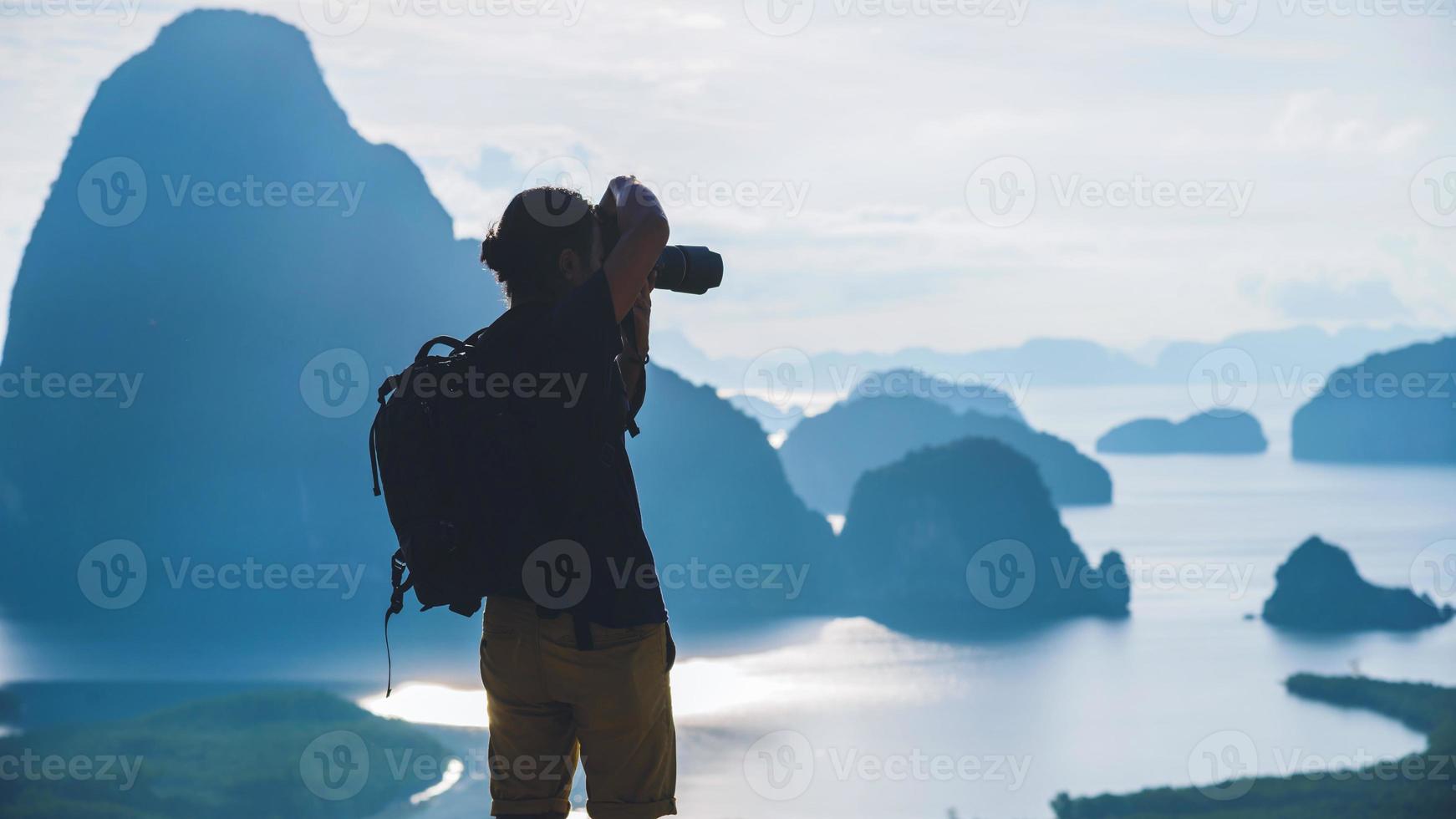 män reser fotografering på berget. turist på sommarlov. landskap vackra berg på havet vid samet nangshe utsiktspunkt. phang nga bay, resor thailand, reseäventyr natur. foto