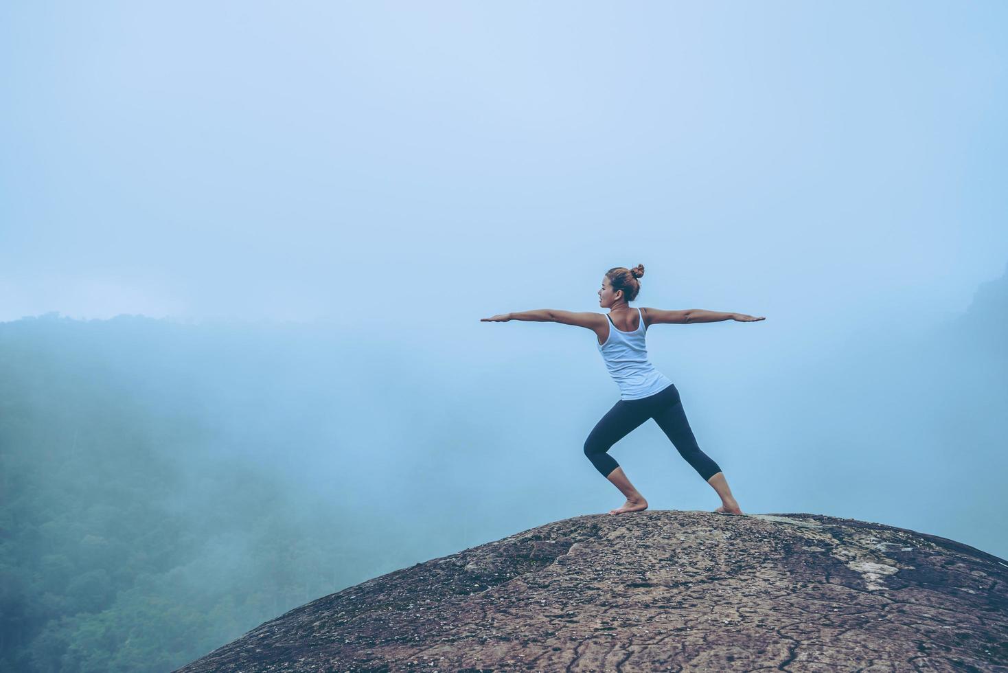 asiatiska kvinnor koppla av i semestern. resa slappna av. spela om yoga. på bergsklippan. natur bergsskogar i thailand foto