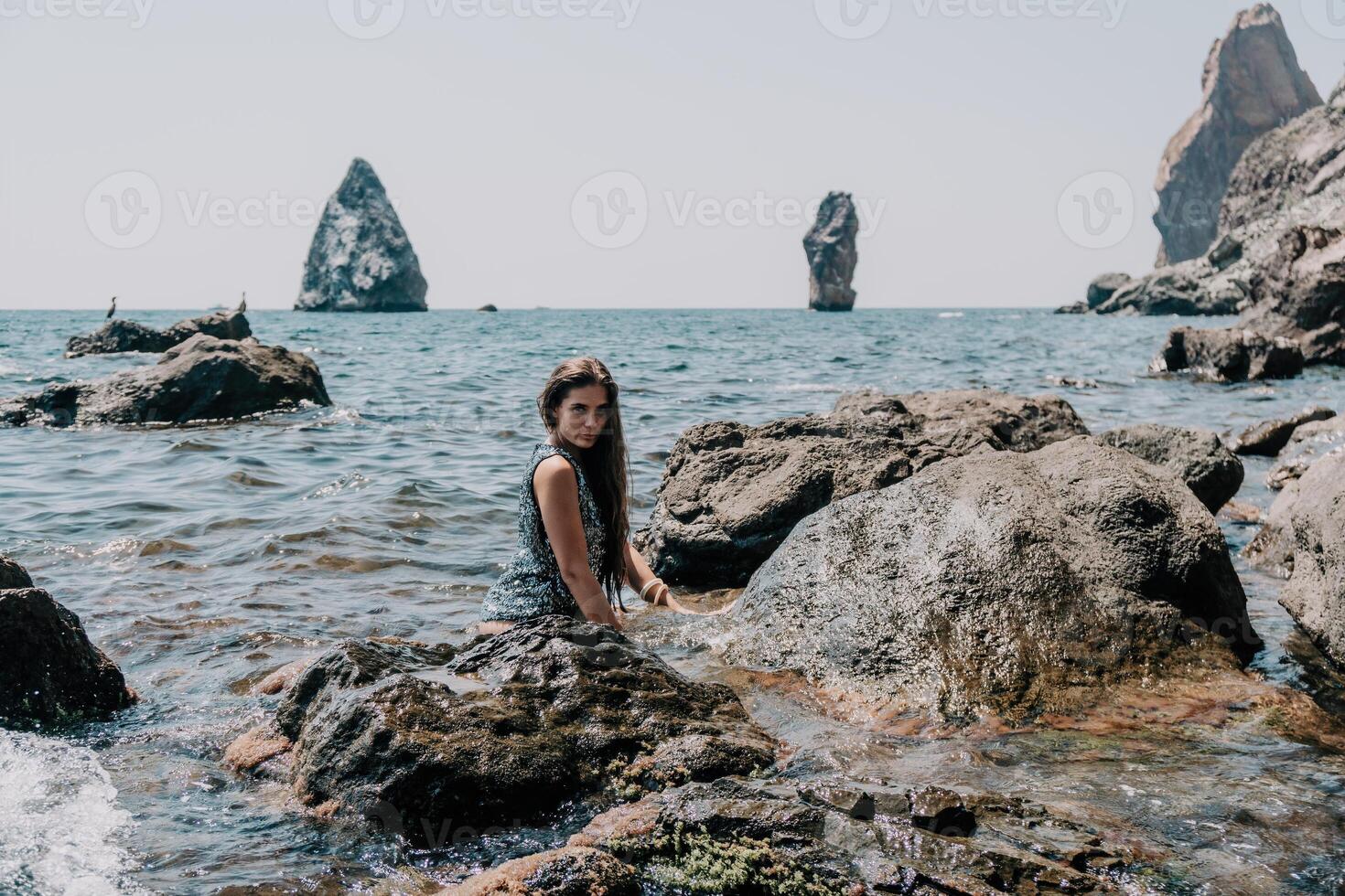 kvinna sommar resa hav. Lycklig turist njut av tar bild utomhus för minnen. kvinna resande Framställ på de strand på hav omgiven förbi vulkanisk berg, delning resa äventyr resa foto