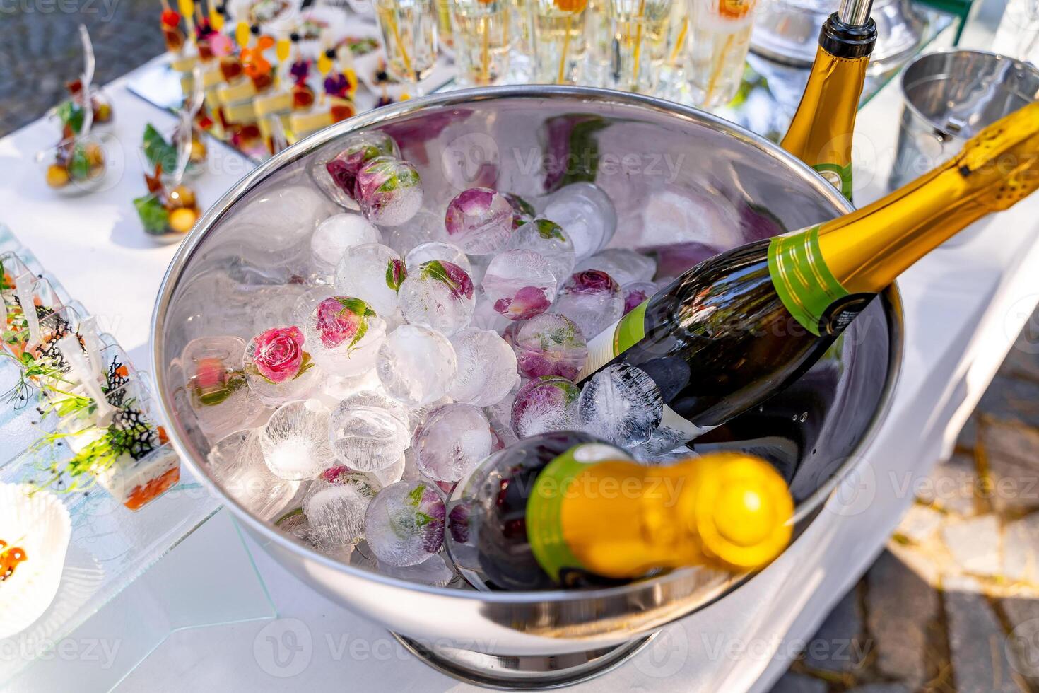 lyx Semester sammansättning. en flaska av kyld champagne i ett is hink och årgång glasögon. festlig tabell i de bakgrund. foto