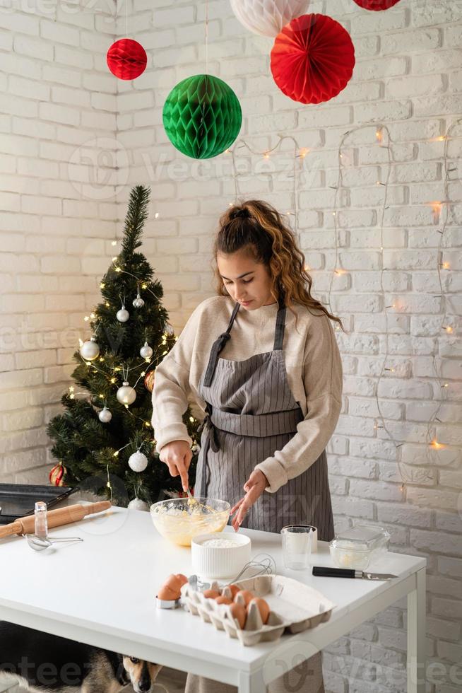 leende kvinna i köket baka julkakor foto