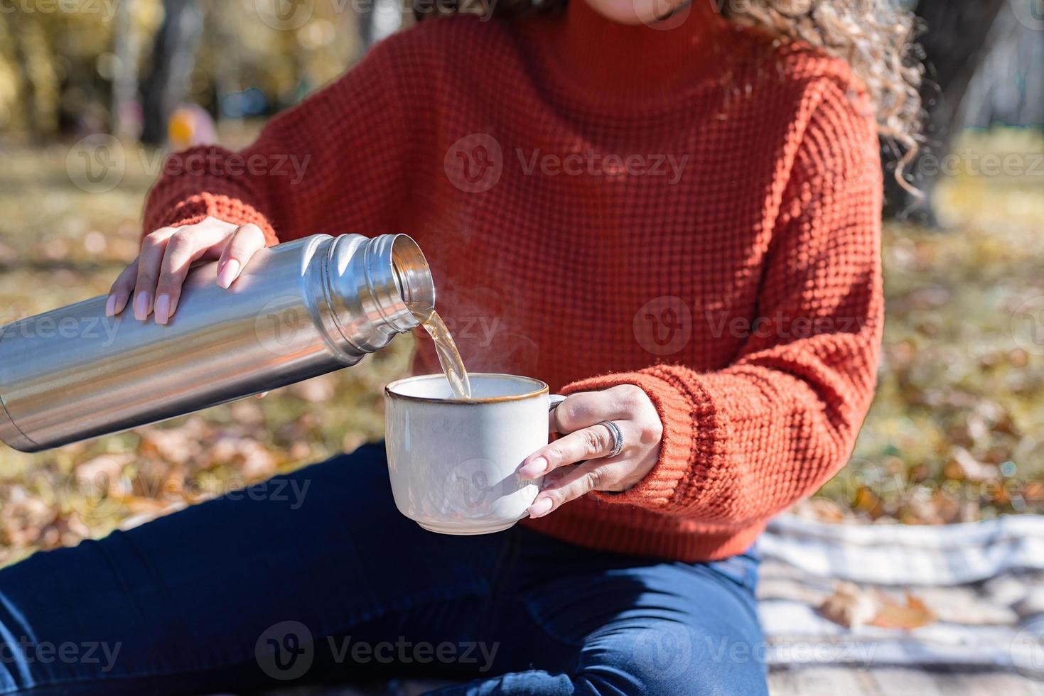 vacker kvinna i röd tröja på en picknick i en höstskog foto